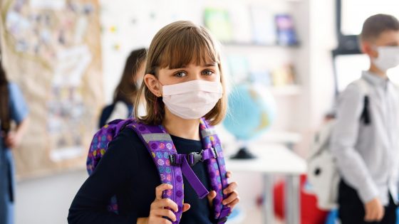 Young girl in classroom wearing facemask