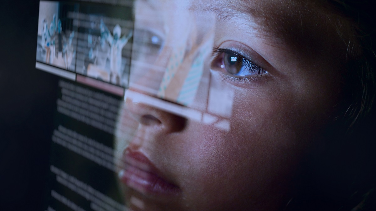 Young child staring at screen, face lit up by the screen