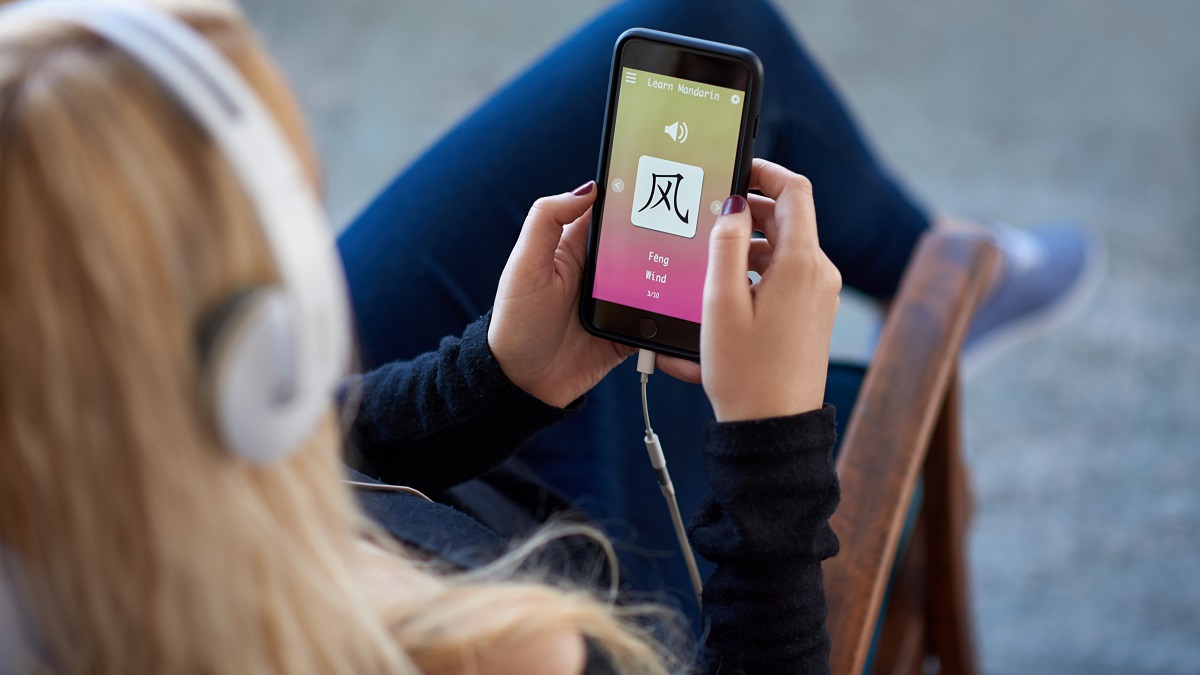 Woman learning mandarin chinese on mobile phone application